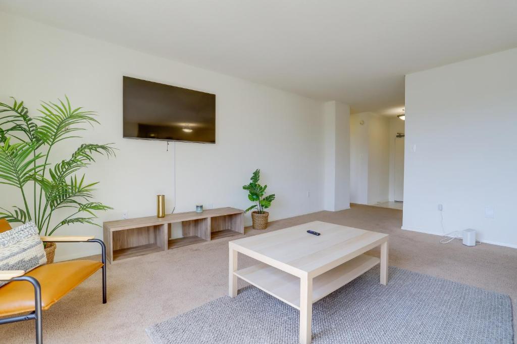 a living room with a table and a tv on the wall at Cozy 2 BR Apartment At Arlington With Gym in Arlington