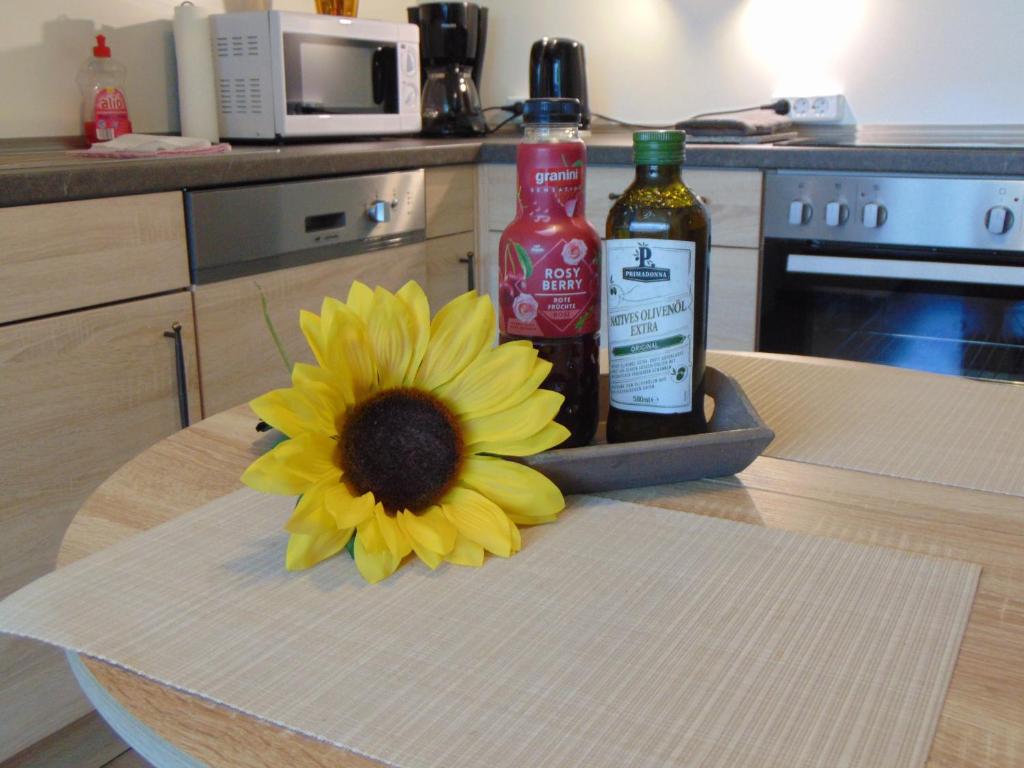 a yellow flower sitting on a table with two bottles of alcohol at Ridders Ferienpark 1 319 in Hahnenklee-Bockswiese