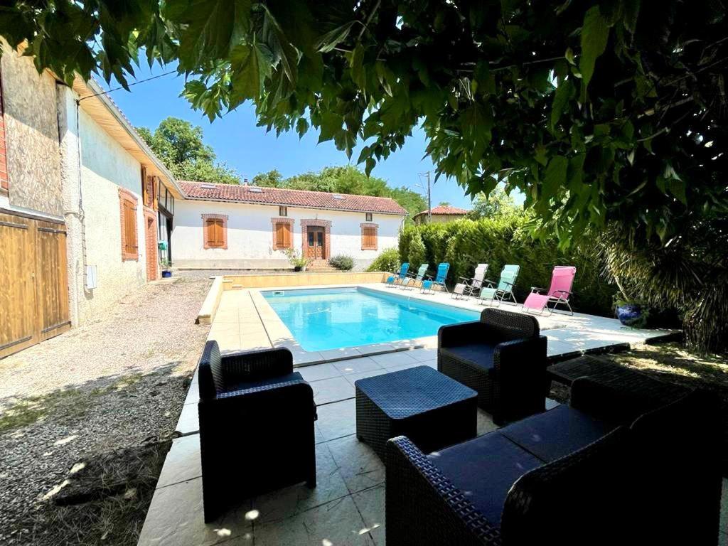 a swimming pool in a yard with chairs and a house at Maison de campagne chaleureuse in Mun