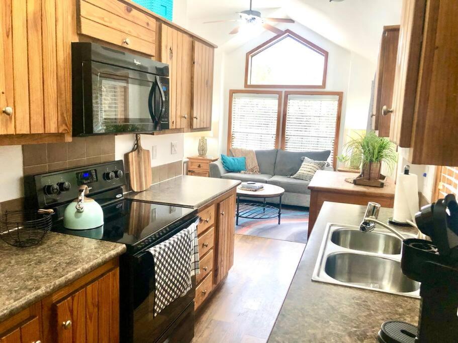 uma cozinha com um lavatório e um fogão forno superior em The Coyote Cabin - Cabins at Rim Rock em Austin