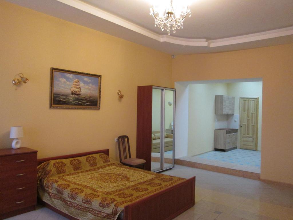 um quarto com uma cama, uma cómoda e um espelho em Rishelyevskiy em Odessa
