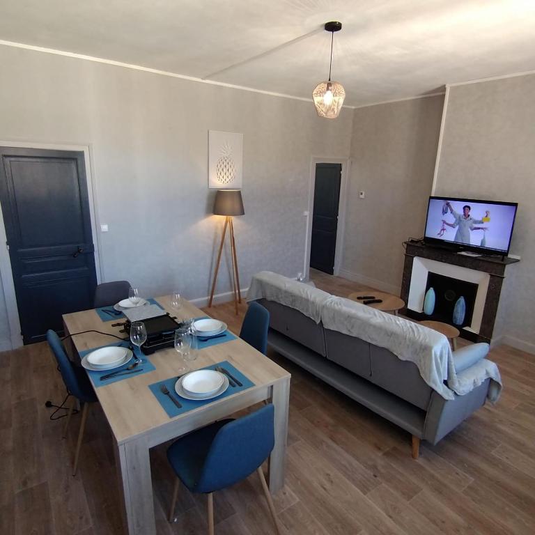 a living room with a table and a couch at Halles Brauhauban Tarbes - T6 en collocation - Louez votre chambre in Tarbes