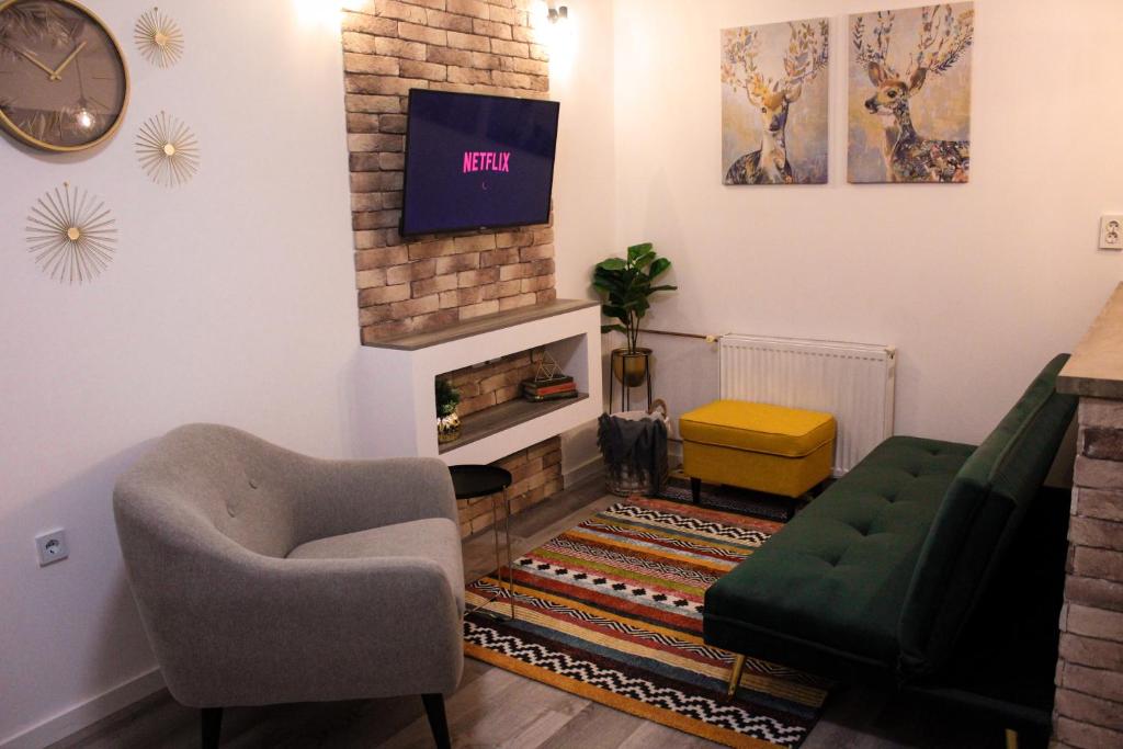 a living room with a tv on a brick fireplace at Apartment Sleep & Fly Zagreb Airport in Velika Gorica