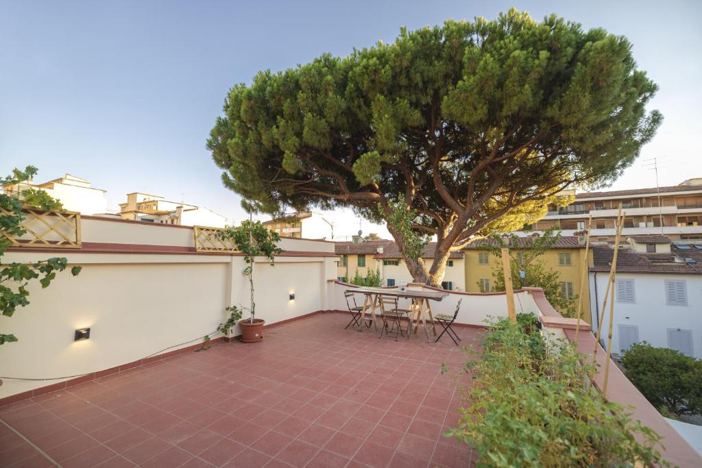 a patio with a table and a tree on it at Casaldo's rooms in Florence