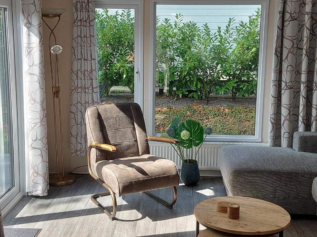 ein Wohnzimmer mit einem Stuhl und einem Sofa in der Unterkunft Chalet Wanama. Gelegen op het vakantiepark Het Lierderholt op de veluwe. in Beekbergen