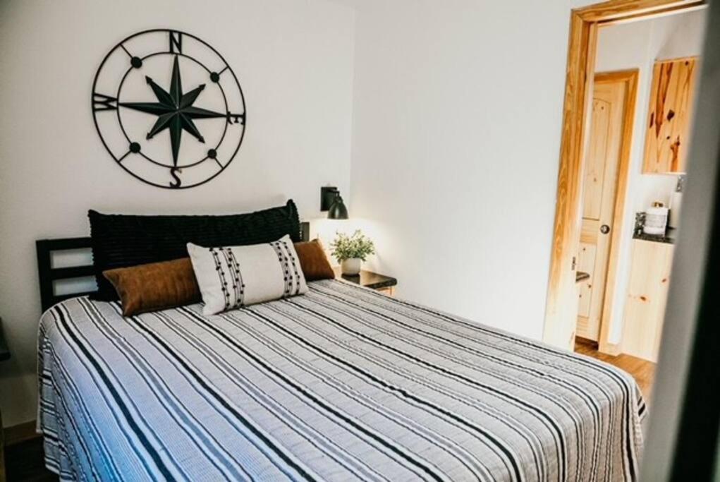 a bedroom with a bed with a large clock on the wall at The Bison Cabin - The Cabins at Rim Rock in Austin