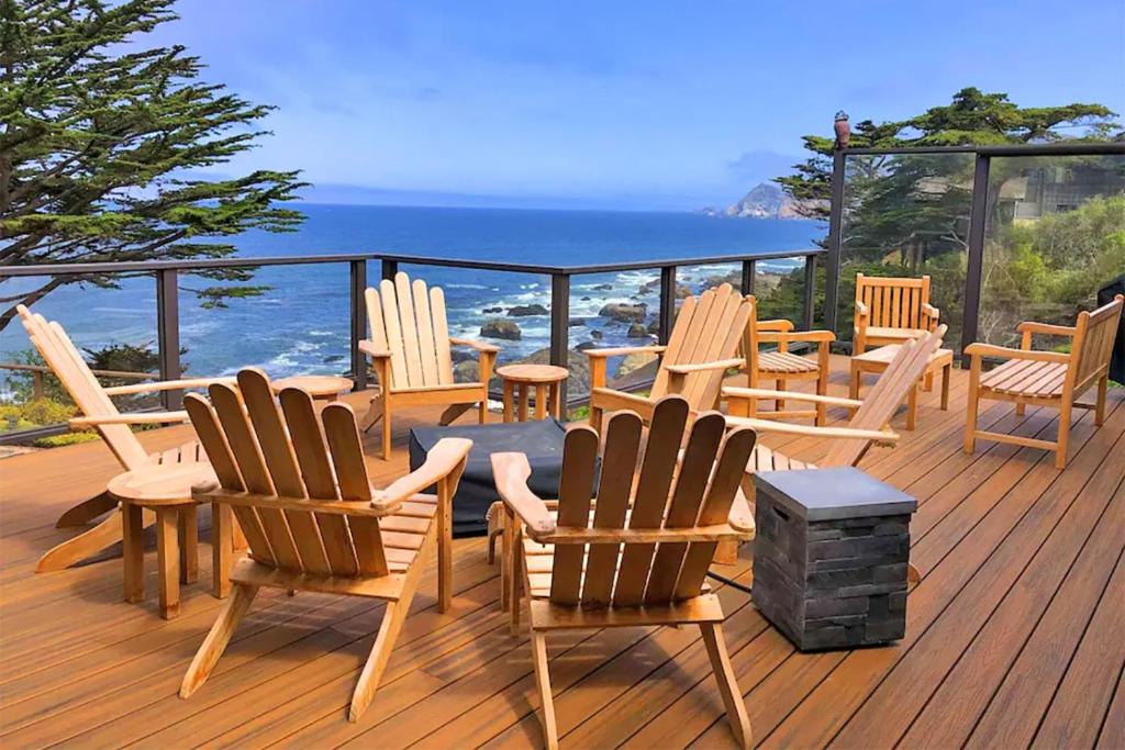 a group of chairs and tables on a deck with the ocean at Entire Private Coastal Retreat - Spectacular Ocean Views wHot Tub in Montara