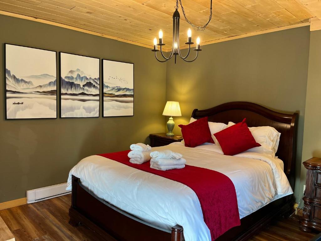a bedroom with a large bed with red pillows at Frigon Suite -Waterfront in Port Alice