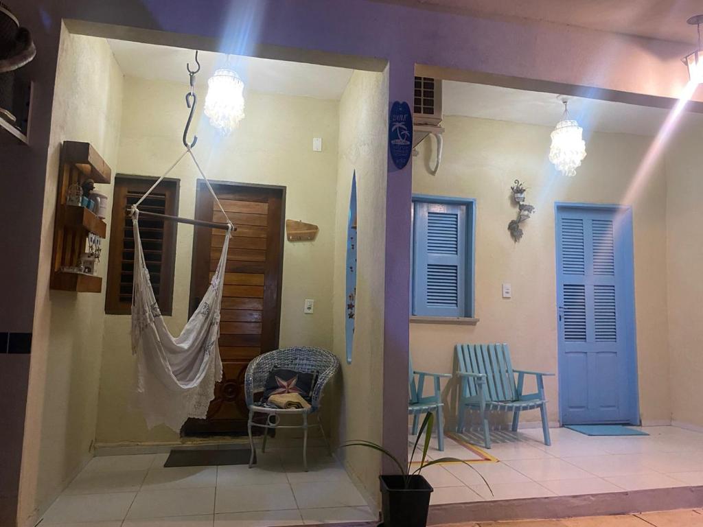 a room with two chairs and a hammock in a house at Pousada Paracuru Surf in Paracuru