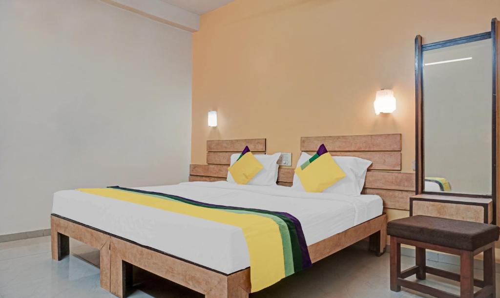 a bedroom with a large bed and a chair at Itsy By Treebo - Ranjeet in Kolhapur