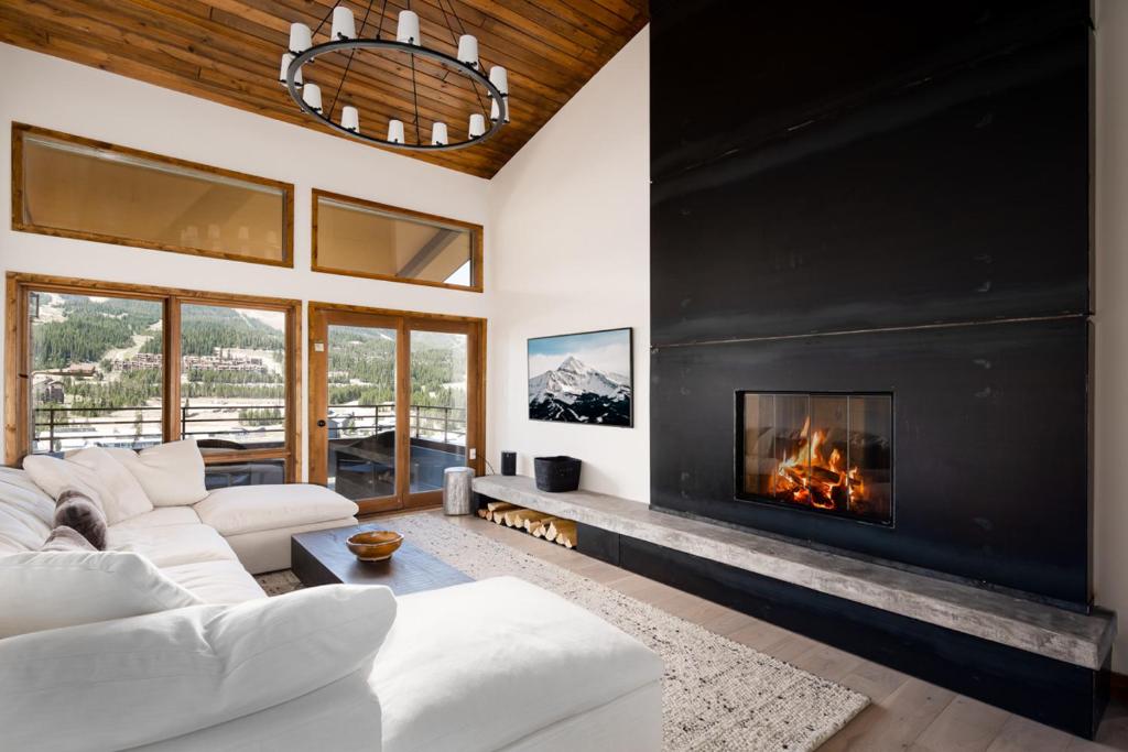 a living room with a fireplace and a white couch at Skycrest Penthouse 1733 in Big Sky