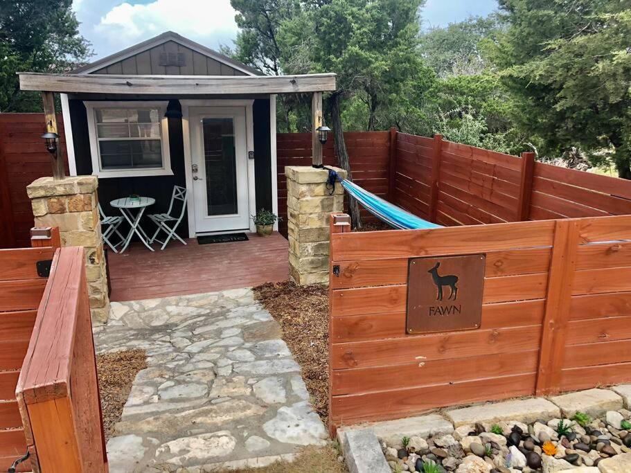 einen Hinterhof mit einem Zaun und ein Haus mit einer Hängematte in der Unterkunft The Fawn Cabin - The Cabins at Rim Rock in Austin