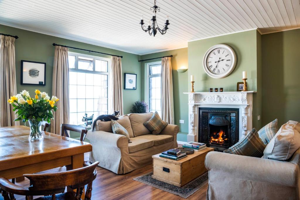 Margaret's Cottage B&B في Ardglass: غرفة معيشة مع أريكة ومدفأة