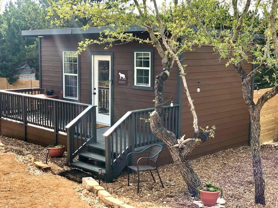 a small house with a porch and a chair in front of it at The Bobcat Cabin - The Cabins at Rim Rock in Austin