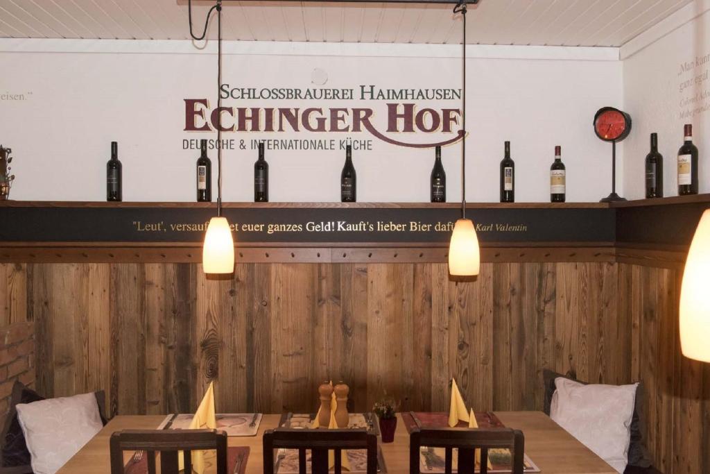 un comedor con botellas de vino en la pared en Echinger Hof bei München, en Eching