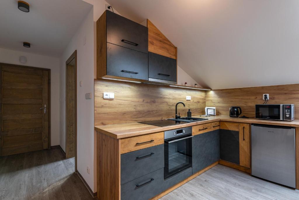 a kitchen with wooden cabinets and a sink at Apartmány Lucie in Jihlava