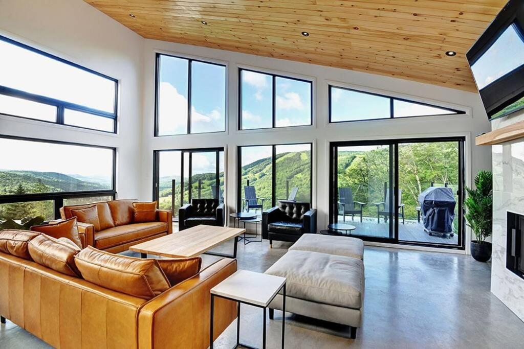 a living room with a couch and a fireplace at Blanc 24 - Les Chalets Alpins, Stoneham in Stoneham