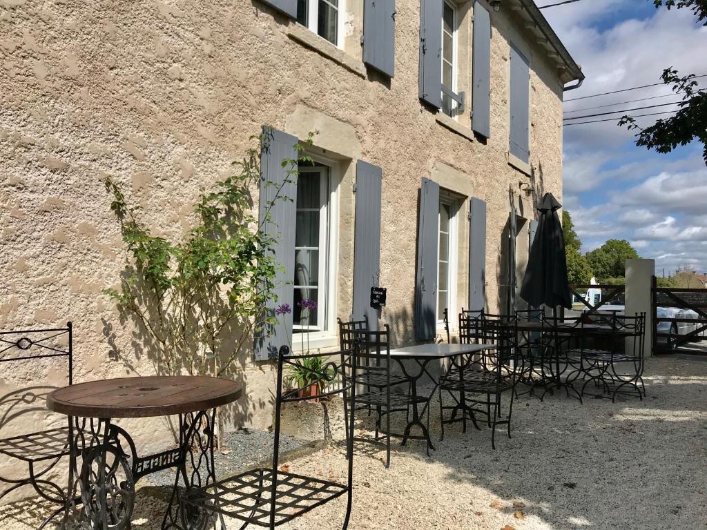 a group of tables and chairs outside of a building at Le Relais D'Aulnay in Aulnay