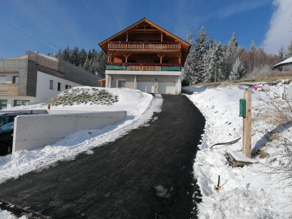 a house in the snow with a driveway at Wald-Panorama-Zimmer in Mönichkirchen