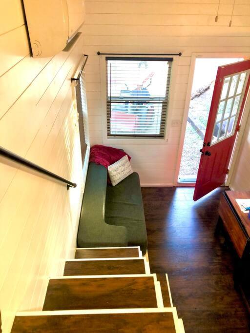 eine Treppe in einem winzigen Haus mit grüner Couch in der Unterkunft Fox Tiny Home - The Cabins at Rim Rock in Austin