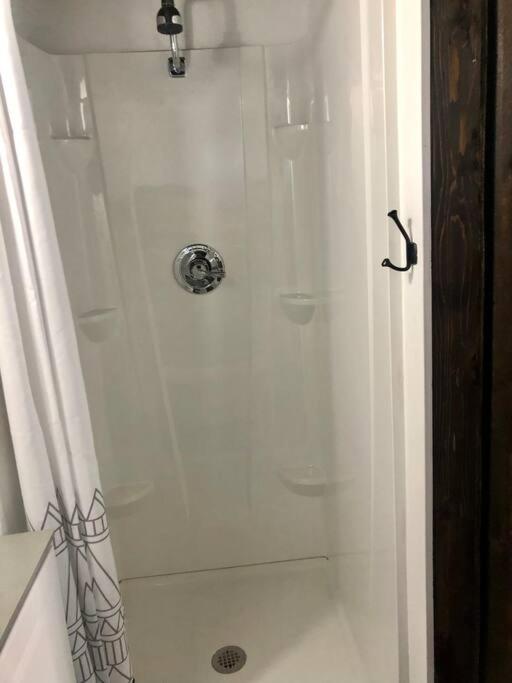 eine weiße Dusche im Bad mit Dusche in der Unterkunft Fox Tiny Home - The Cabins at Rim Rock in Austin