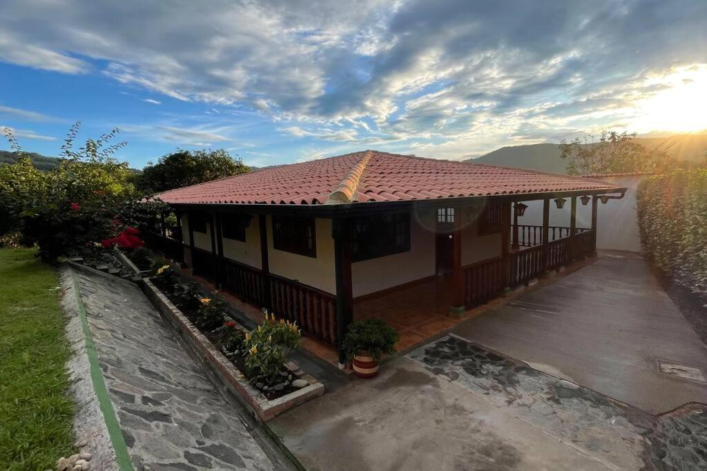 une maison avec une terrasse couverte et une allée. dans l'établissement Alojamiento Casa Campestre, à Guaduas