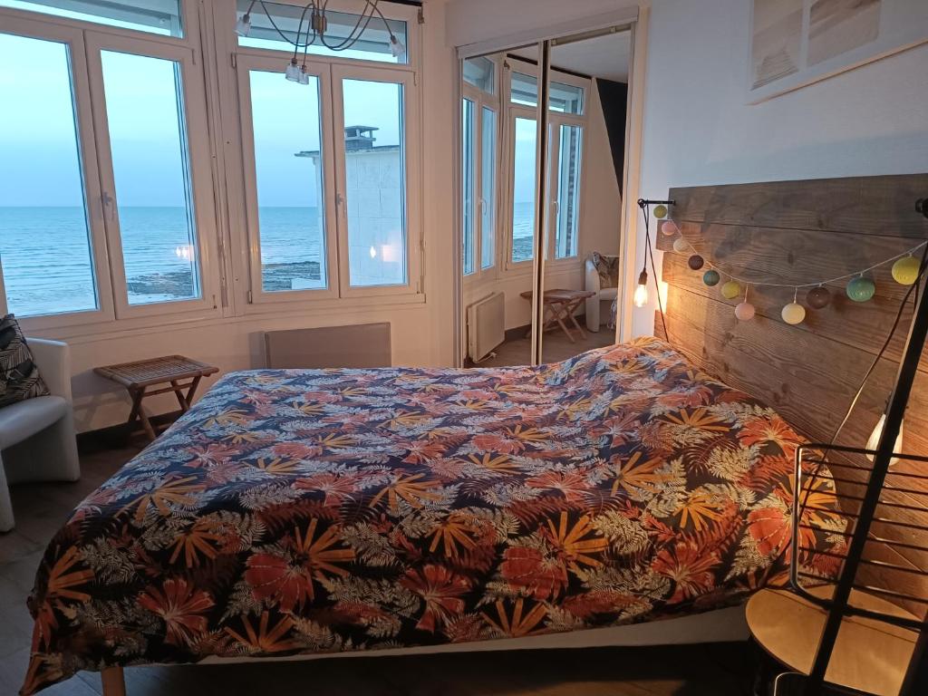 a bedroom with a bed with a colorful bedspread at Appartement Cosy in Ault