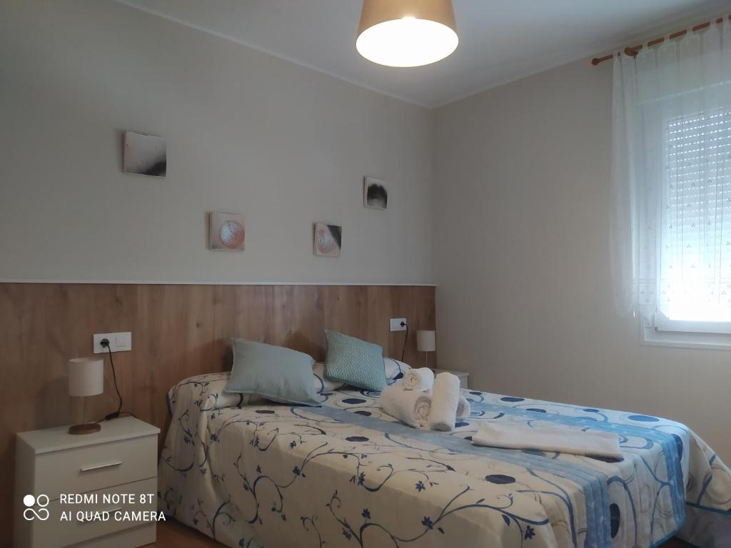 a bedroom with a bed with towels on it at Vivienda turística Ramón Trillo en Muxía in Muxia