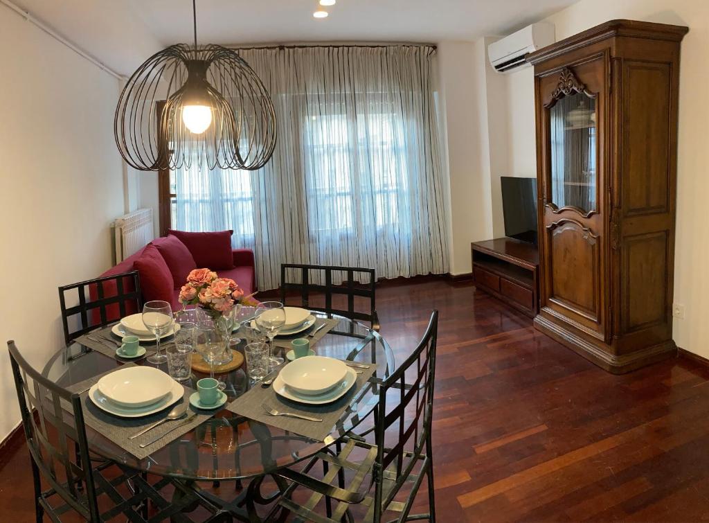 una sala da pranzo con tavolo e sedie in vetro di Apartamento El Temple-Casco histórico de Zaragoza a Saragozza