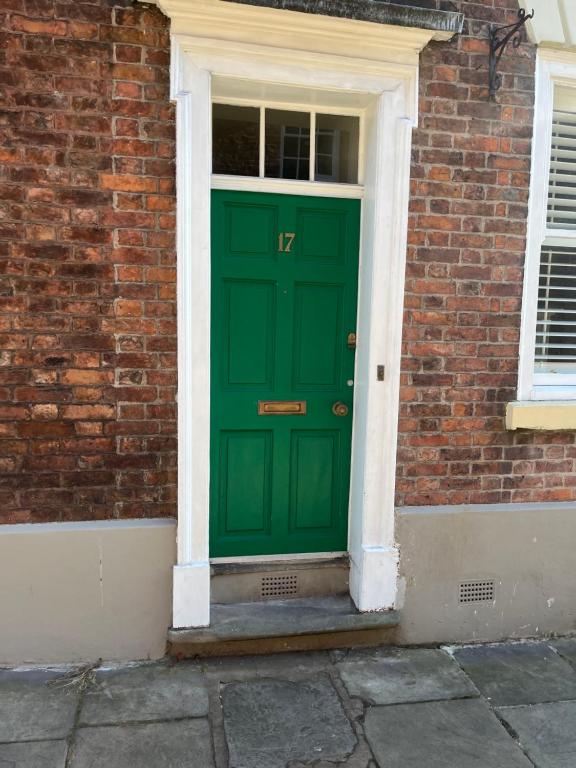 een groene deur aan de zijkant van een bakstenen gebouw bij 18th Century Townhouse in Chester city centre in Chester