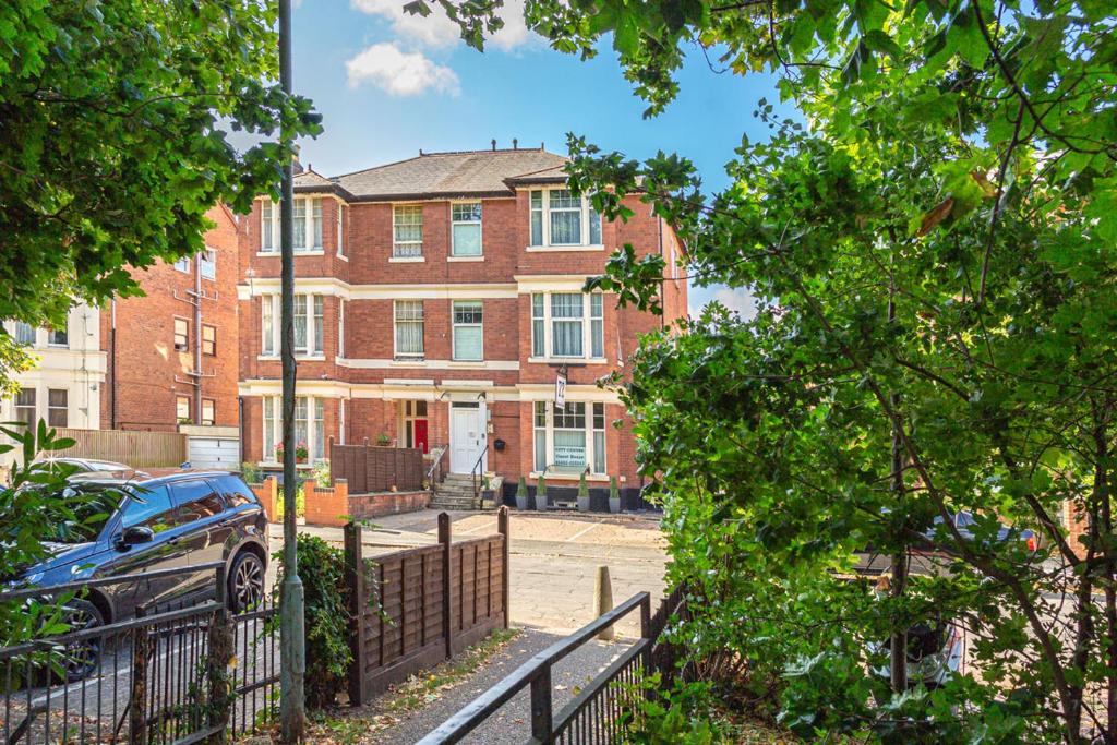 una gran casa de ladrillo con un coche aparcado delante de ella en City Centre Guest House, en Gloucester