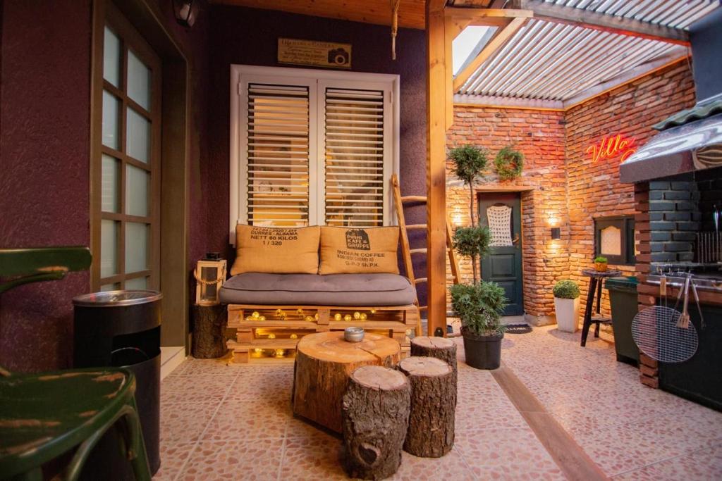 een patio met een bank en een tafel in een kamer bij Villa Elezi in Korçë