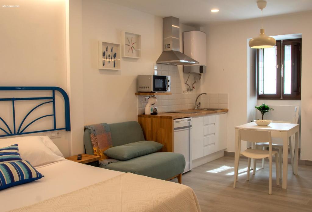 a small bedroom with a bed and a kitchen at Marujita Vilanova, alojamiento singular in Villanueva de Arosa