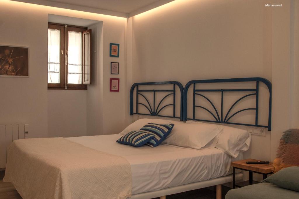 a bedroom with a bed with a blue headboard at Marujita Vilanova, alojamiento singular in Villanueva de Arosa