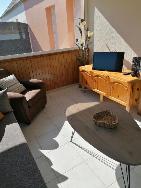 salon ze stołem i kanapą w obiekcie Gite de la Courtoisie w mieście Gavray