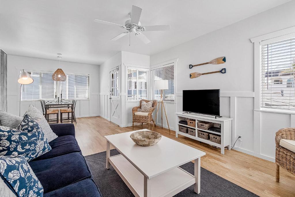 a living room with a blue couch and a tv at Newport Coastal Comfort in Newport Beach