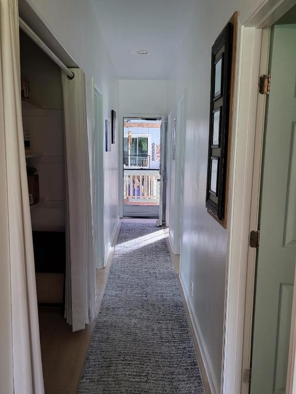 a hallway with white walls and a rug on the floor at Hoomaikai Blessings in Keaau