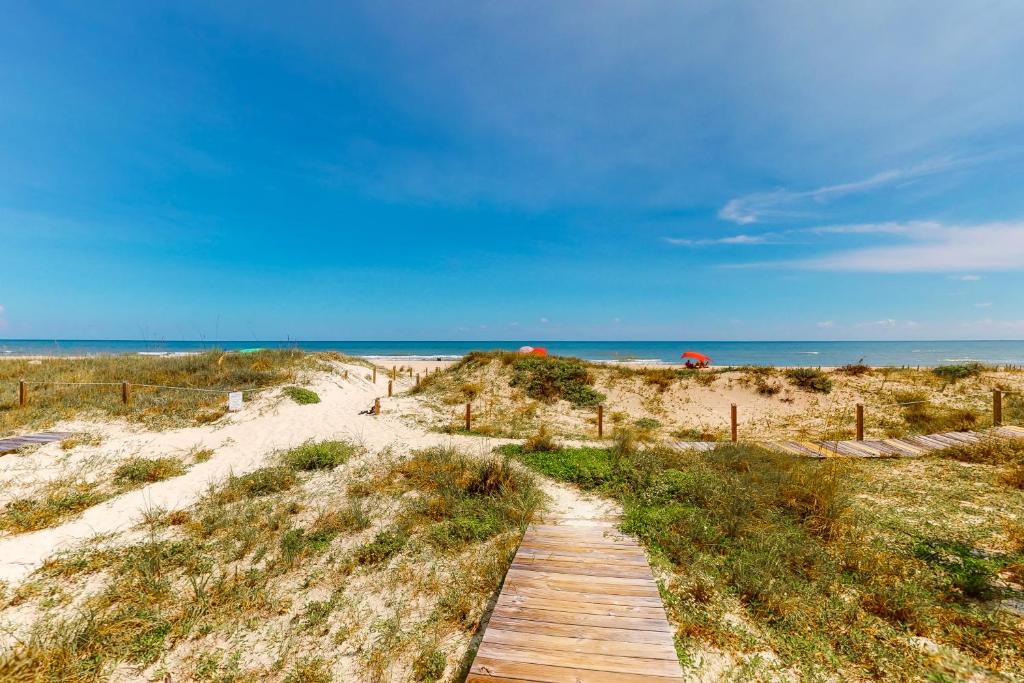 a wooden path to the beach with the ocean in the background at A Sea Of Sand & Stars in St. George Island