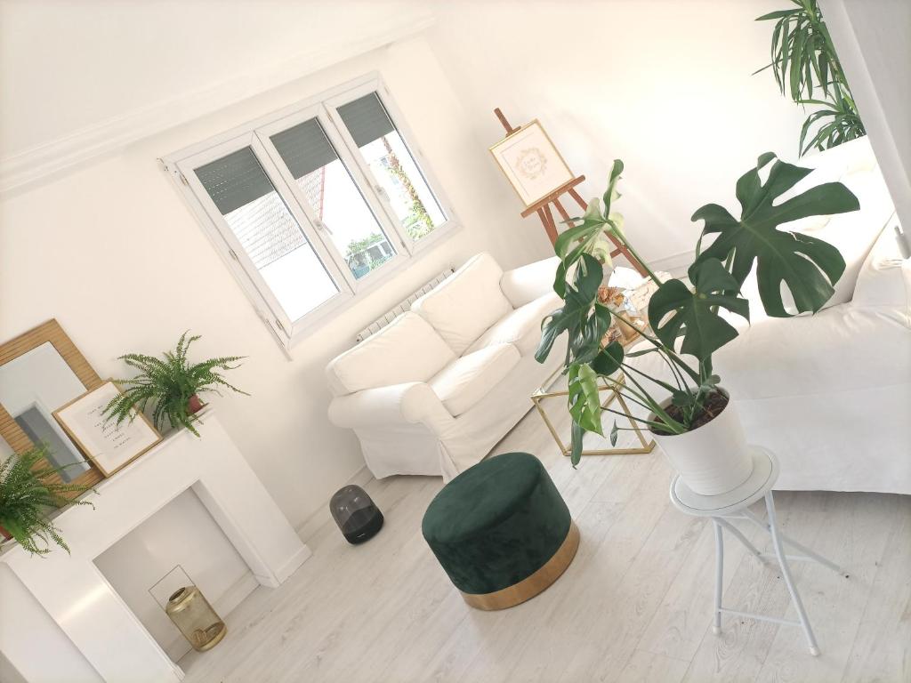 sala de estar con sofá blanco y planta en Guibert Home - Appartement spacieux à 20 min de Paris, en Villeneuve-le-Roi