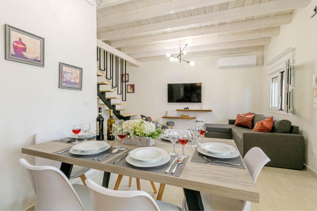 ein Esszimmer und ein Wohnzimmer mit einem Tisch und Stühlen in der Unterkunft S&K Luxury Μaisonette in Potamós