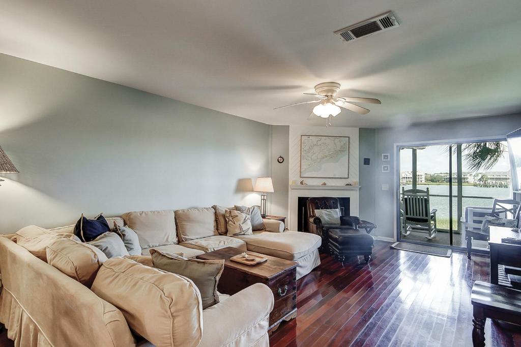 a living room with a couch and a ceiling fan at Mariners Cay 40 in Folly Beach