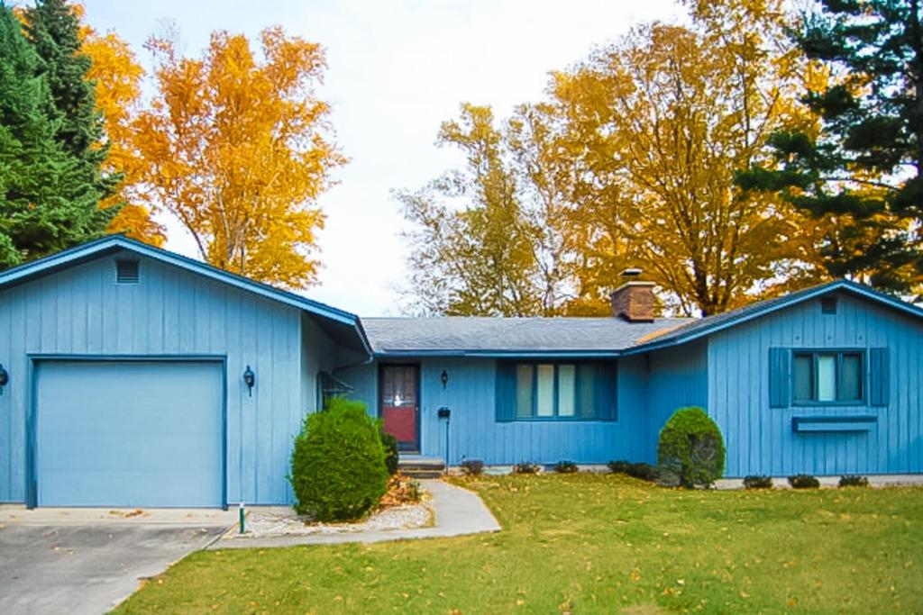 una casa blu con garage di Bywater Bungalow a Empire