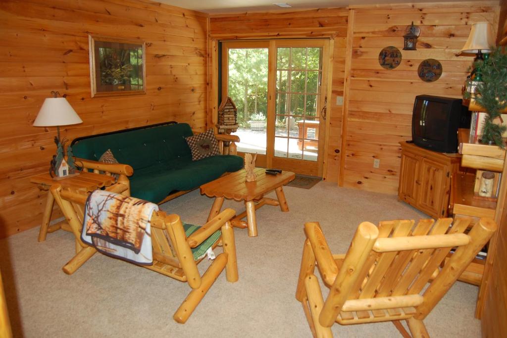 a living room with a couch and chairs in a cabin at Ridge Wood in Empire