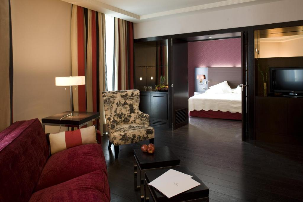 a hotel room with a couch and a bed at Hotel Boutique Gareus in Valladolid