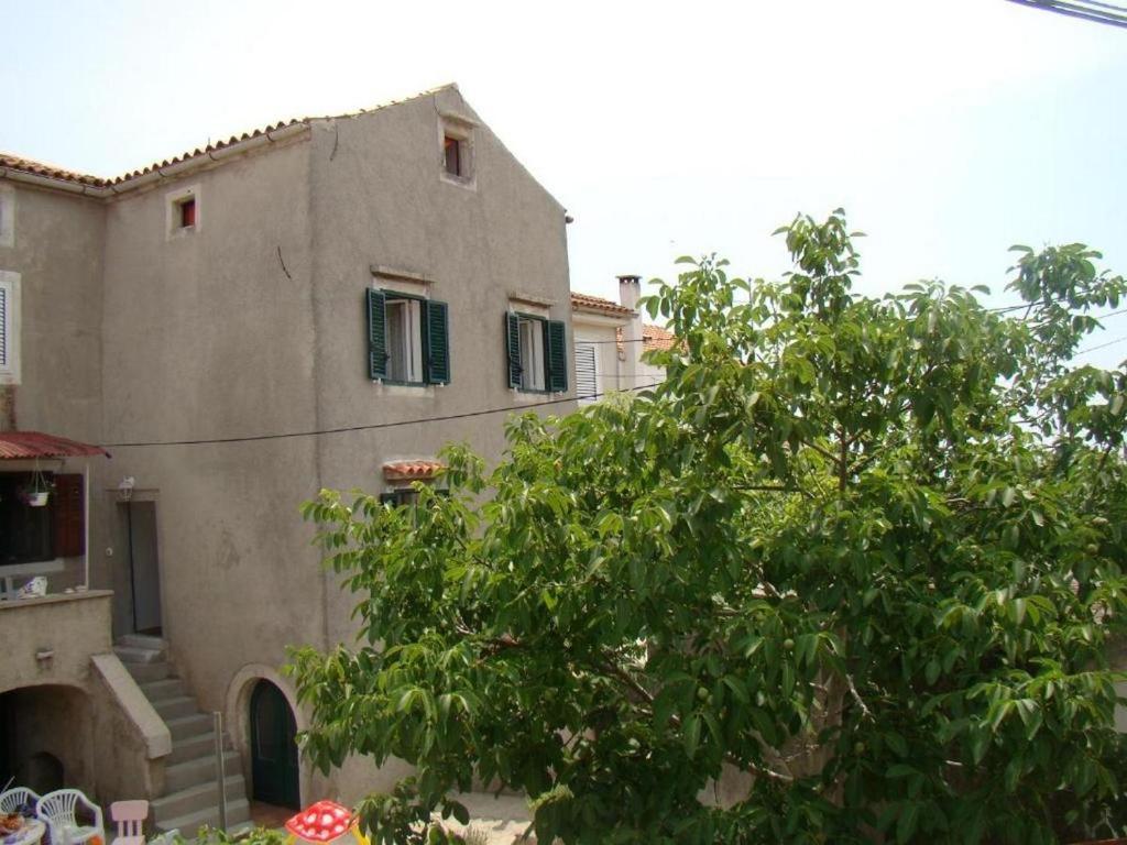 a building with a tree in front of it at Holiday house with a parking space Orlec, Cres - 19938 in Cres