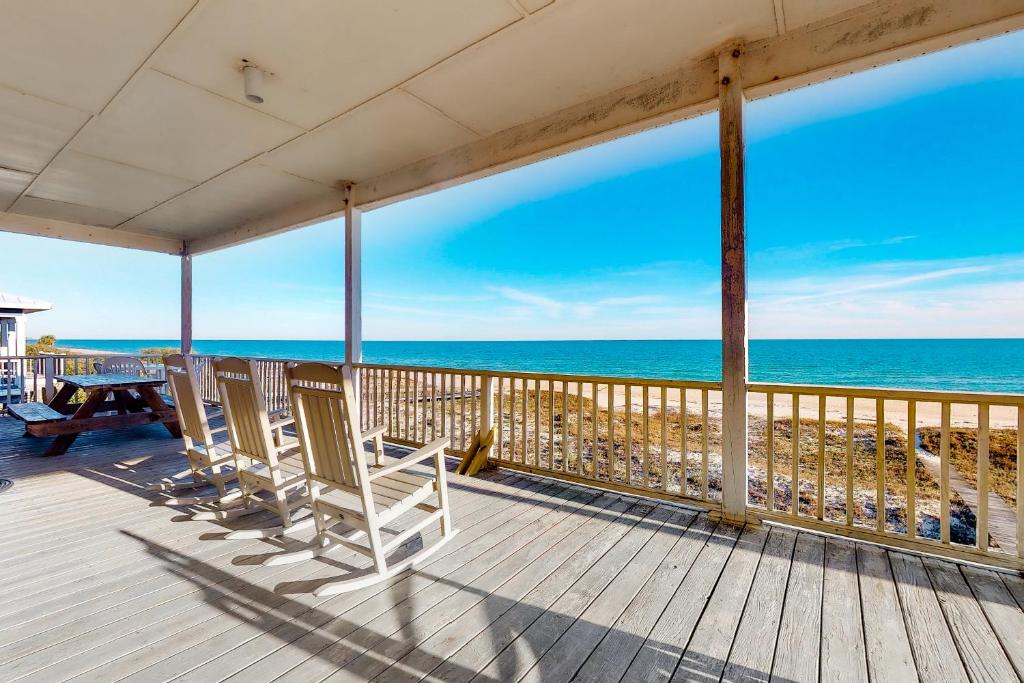 a deck with chairs and a view of the ocean at Sandstone in St. George Island