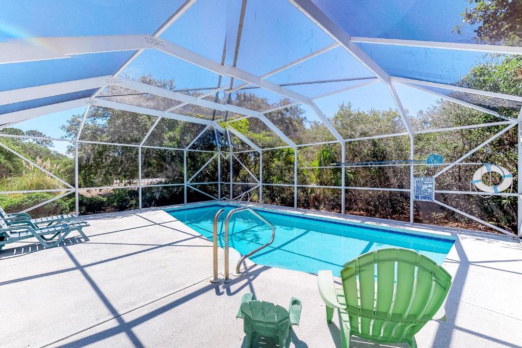 a swimming pool with a glassconservatory with chairs and a swimming pool at Abbeyfeale in St. George Island