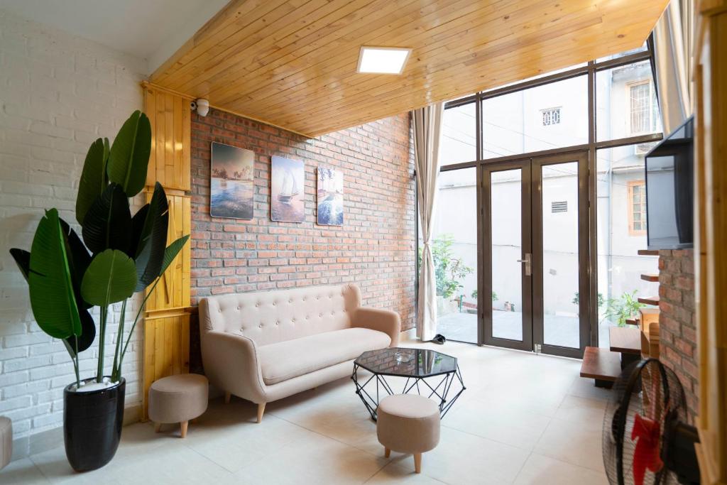 a living room with a couch and a brick wall at Private room in Halong center in Ha Long