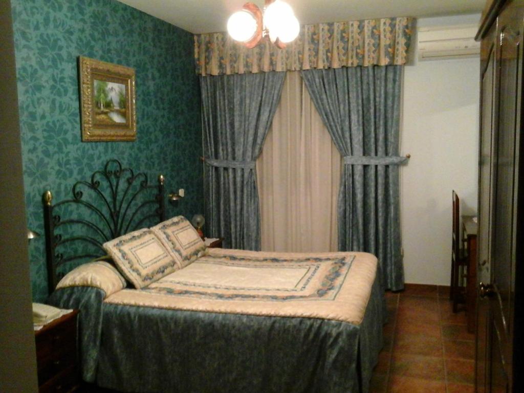 a bedroom with a bed in a room with green walls at Hostal Piñera in Vega de Espinareda