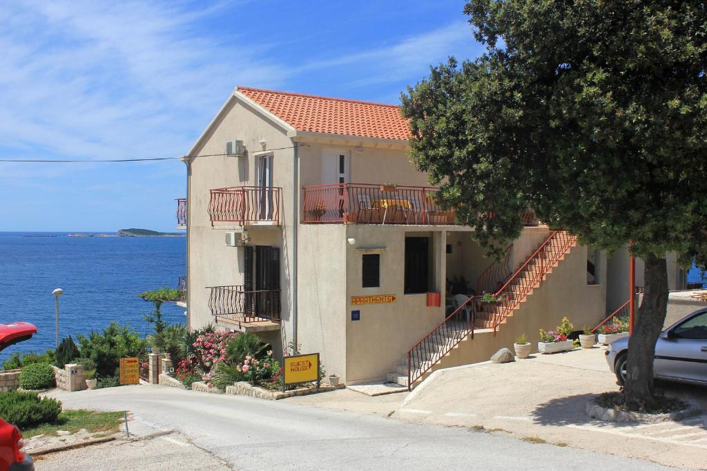 uma casa branca com uma varanda e o oceano em Apartments by the sea Soline, Dubrovnik - 8825 em Mlini